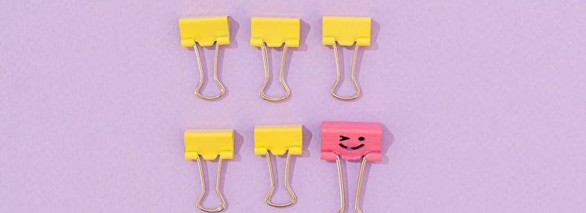 yellow binder clips on a purple surface